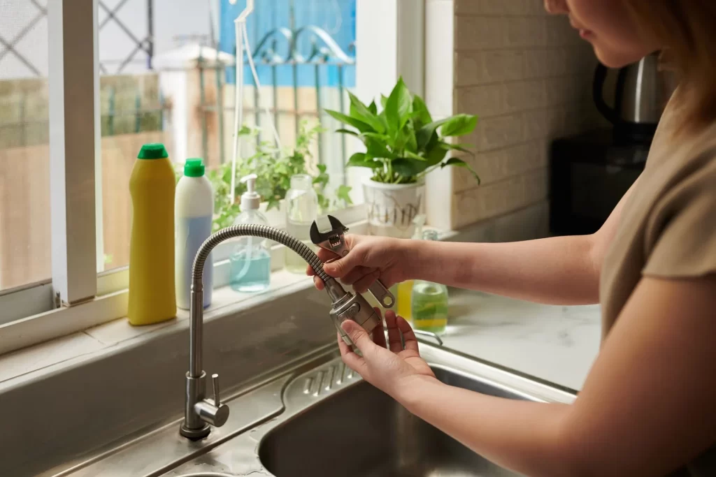 Woman removing kitchen tap