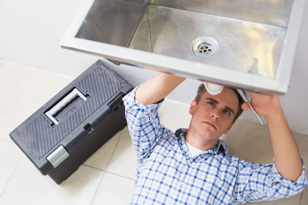 Plumber repairing washbasin drain bathroom